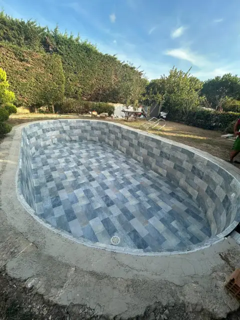Mozaik kaplama aşamasındaki oval bahçe havuzu